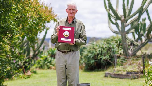 Doctors Creek farmer John Newton with his Bureau of Meteorology Excellence Award at his property on Thursday.