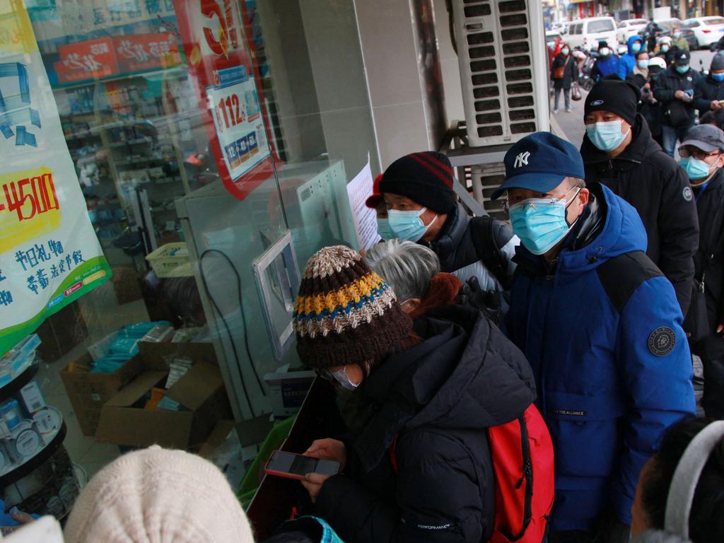 People queue to buy medicine at a pharmacy. Picture: AFP