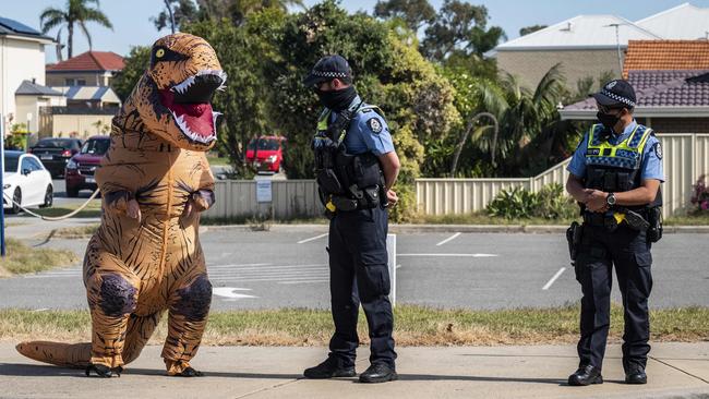 A passer-by in Mark McGowan’s home suburb of Rockingham watches him hold a press conference during the three-day lockdown. Other onlookers shouted compliments to the popular leader. Picture: NCA NewsWire/Tony McDonough