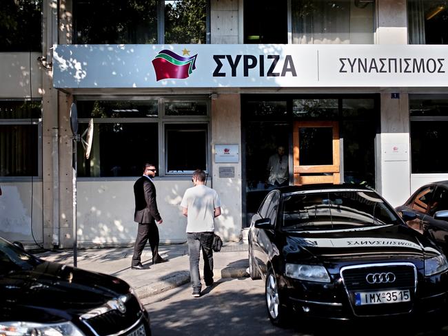 Showdown ... police officers stand outside the headquarters of ruling party Syriza, during a party political committee meeting in Athens. Picture: AFP/Angelos Tzortzinis