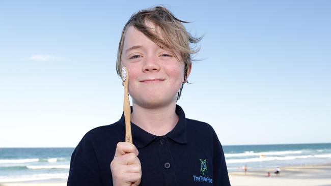 Ned Heaton, 11, of Tamborine Mountain, on the beach with a bamboo toothbrush