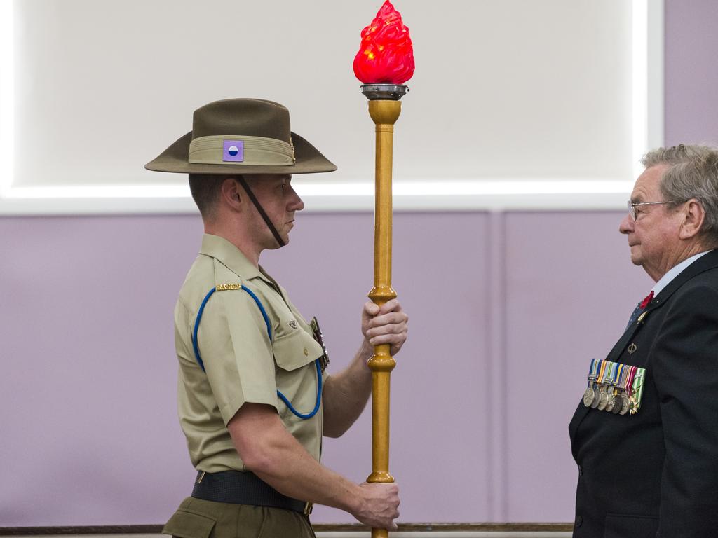 The torch is received by to SIG James Lindsay of the 7th Signal Regiment from Vietnam veteran Lindsay Morrison in the Passing of the Torch ceremony during the Toowoomba Remembrance Day service at Indoor Bowls Hall, Thursday, November 11, 2021. Picture: Kevin Farmer