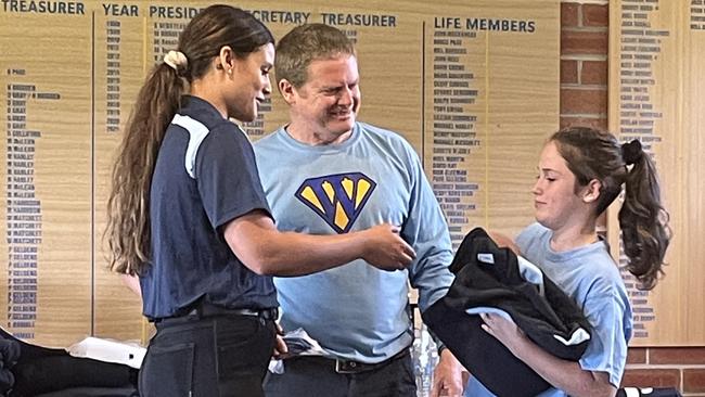 Young rugby player Belle Campbell receiving her special jersey.