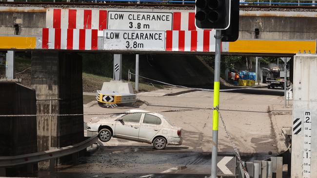 A flood-damaged car under the railway at Rocklea in Brisbane. Picture: Liam Kidston