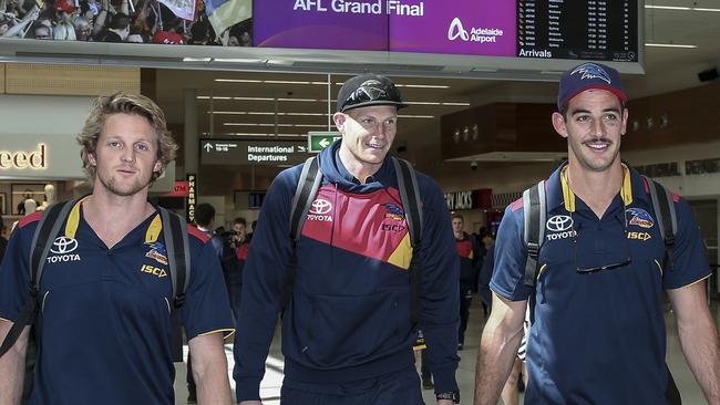 Adelaide Crows players Rory Sloane, Sam Jacobs and Taylor Walker at Adelaide Airport. Picture: Mike Burton/AAP