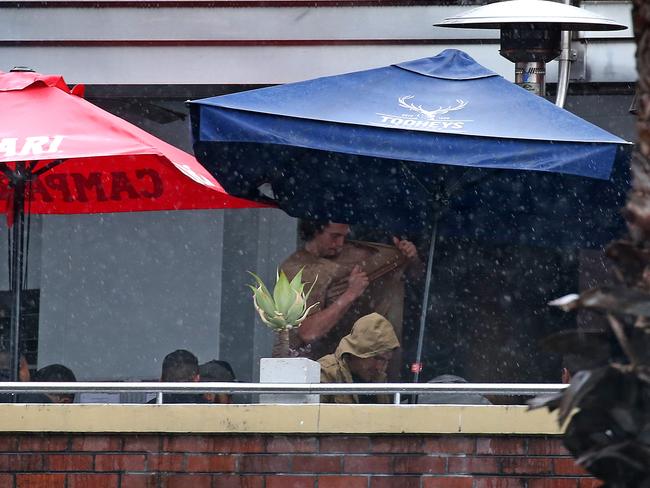 Bulldogs players arrive at the Harbour View Hotel in The Rocks for Mad Monday. A player rips off his shirt and throws it over the balcony. Picture: Toby Zerna