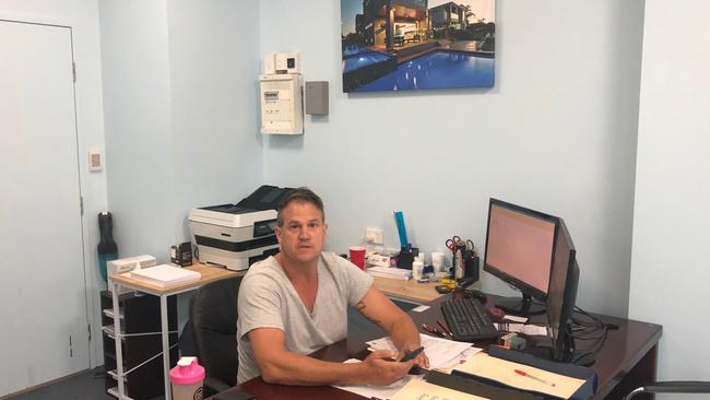 Builder Adrian Hill was photographed working in an office in Broadbeach displaying his construction company's signage despite him and the company being unlicensed. Photo: Supplied 