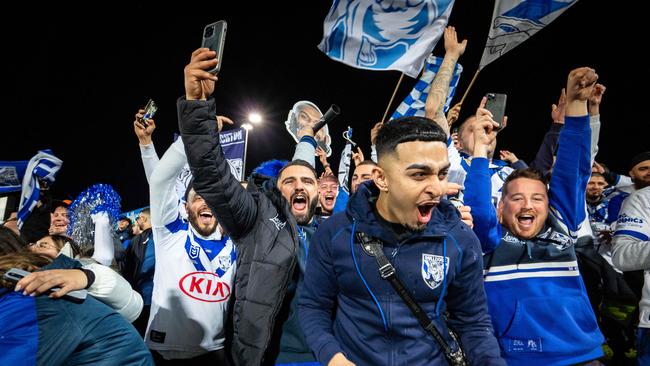 Bulldogs fans celebrate their teams win over the Dragons at Jubilee oval on Saturday night.Photo: Tom Parrish