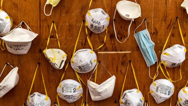 Protective masks bearing the names of medical staffers and nurses are pinned to a wall at a field hospital in Lombardy. Picture: AFP.