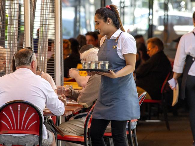 MELBOURNE, AUSTRALIA - NewsWire Photos December 13 2020: Waiters working  on a busy Lygon St Carlton on Sunday afternoon. Hospitality staff could be paid as much as $1000 in sign-on bonuses as Melbourne venues work desperately to find enough staff to meet demand from fresh out of lockdown residents.Picture: NCA NewsWire / David Geraghty