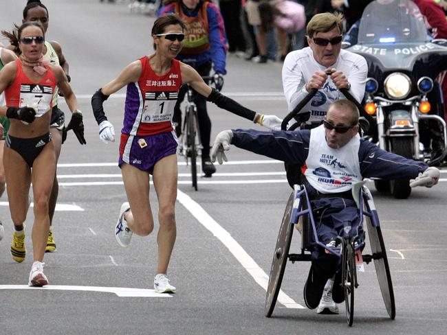 Dick Hoyt, right, runs with his son Rick for their 25th Boston Marathon, as Japanese runner Reiko Tosa (F1) looks on in Ashland, Mass., during the 110th Boston Marathon, Monday, April 17, 2006. (AP Photo/Chitose Suzuki)