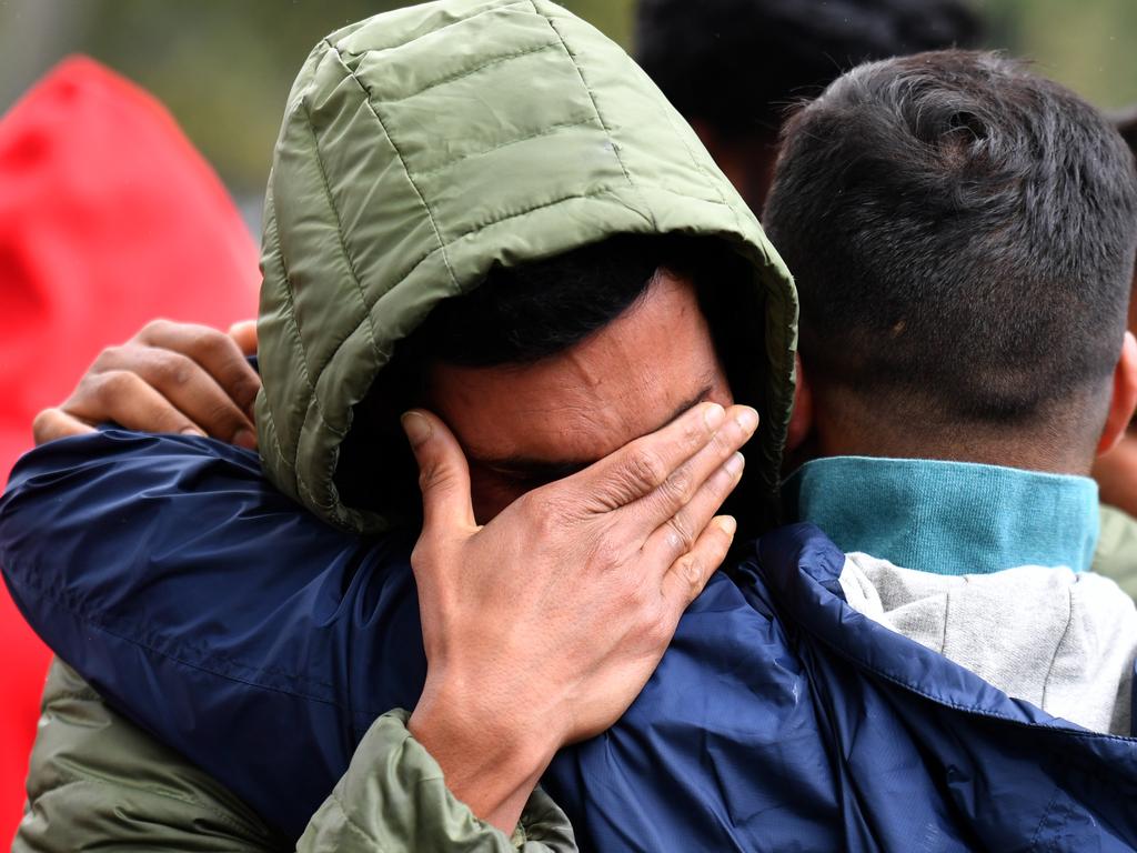 Friends of a missing man grieve outside a refuge centre in Christchurch. Picture: AAP 