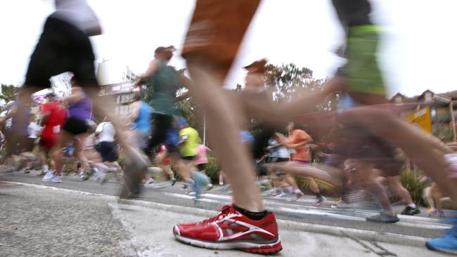 Some of the more than 80,000 registered runners race up Williams Street in Sydney, Sunday, Aug. 10, 2014, at the start of the City 2 Surf annual fun run. Competitors are running the 14 km (8.7 mile) course raising millions of dollars for charities. (AP Photo/Rick Rycroft)