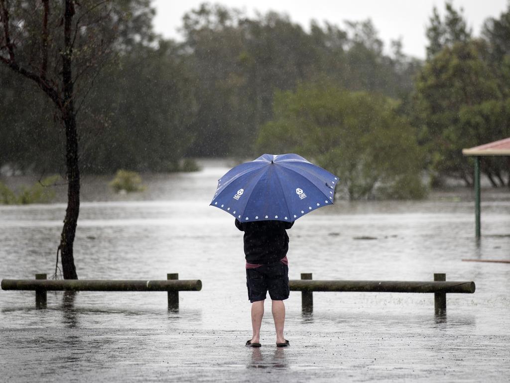 A man looks out over a park submerged by floodwaters in Windsor, New South Wales, on March 22, 2021. It was the second westtest March on record for NSW. Picture: Brent Lewin/Bloomberg via Getty Images