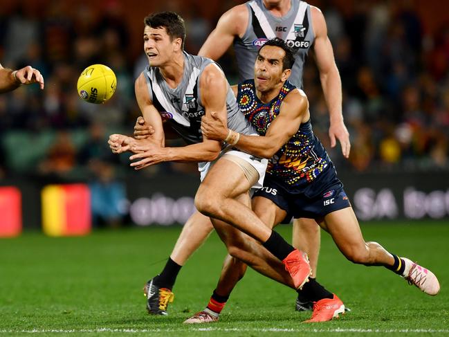 Port Adelaide’s Ryan Burton fires off a handball under pressure from Adelaide star Eddie Betts at Adelaide Oval on Saturday. Picture: Mark Brake/Getty Images