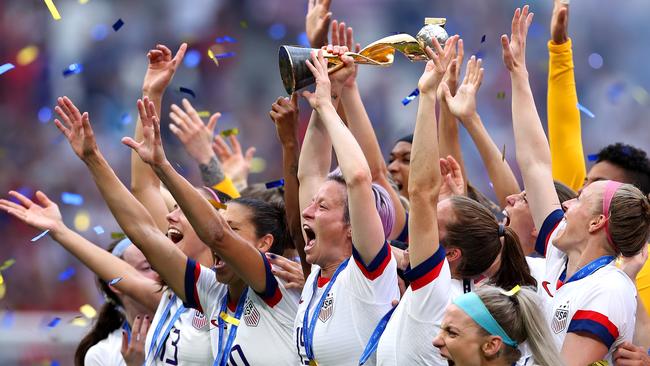 Megan Rapinoe lifts the FIFA Women's World Cup Trophy.