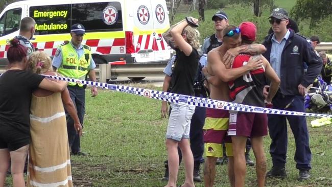 Loved ones of the trail bike rider comfort each other at the crash site on Robert Brown Reserve in Blacktown. Picture: TNV