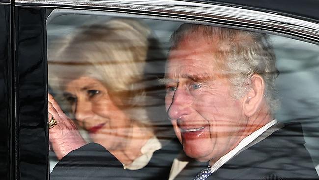 Britain's King Charles III and Britain's Queen Camilla wave as they leave by car from Clarence House in London on February 6, 2024. King Charles III's estranged son Prince Harry reportedly arrived in London on Tuesday after his father's diagnosis of cancer, which doctors "caught early". (Photo by HENRY NICHOLLS / AFP)