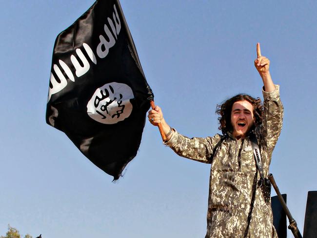 An Islamic State waves the distinctive black jihadist flag during a military parade in Raqqa, 2014. 