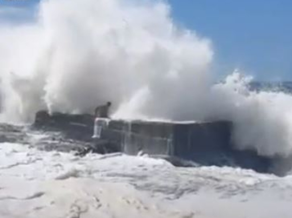 An Aussie man be seen being washed onto rocks by monster surf in QLD. Picture: Instagram/Jacob_little111