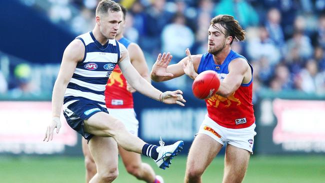 Joel Selwood kicks the ball under pressure from Rhys Mathieson.