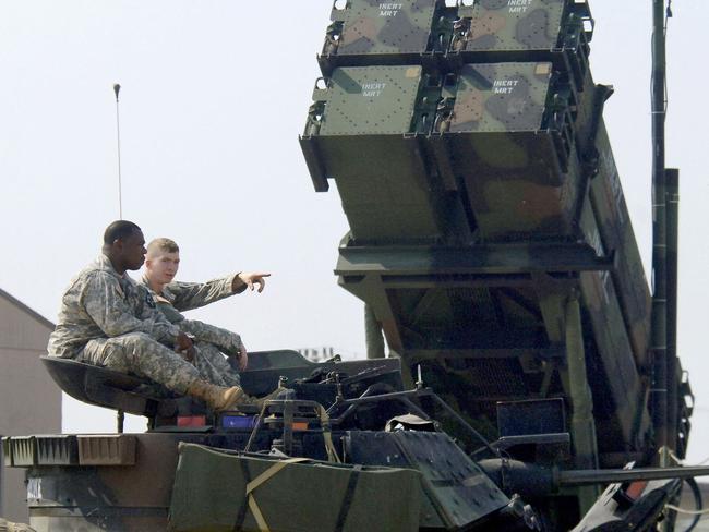 (FILES) This file photo taken on October 14, 2006 shows US soldiers sitting on a turret of the M2A2 Bradley Fighting Vehicle in front of the launcher of a Patriot missile PAC-3 system during Air Power Day at the US air base in Osan, south of Seoul. - The United States said December 21, 2022 it would provide Ukraine with the advanced Patriot air defense system to help counter Moscow's relentless aerial attacks. The system is part of $1.85 billion in security assistance unveiled in parallel with a visit to Washington by Ukrainian President Volodymyr Zelensky, his first trip outside the country since Russia invaded in February. (Photo by Jung Yeon-je / AFP)