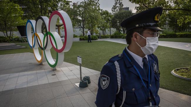 A security worker stands next to the Olympic Rings during a protest against the Tokyo Olympics in Tokyo, Japan. Picture: Getty