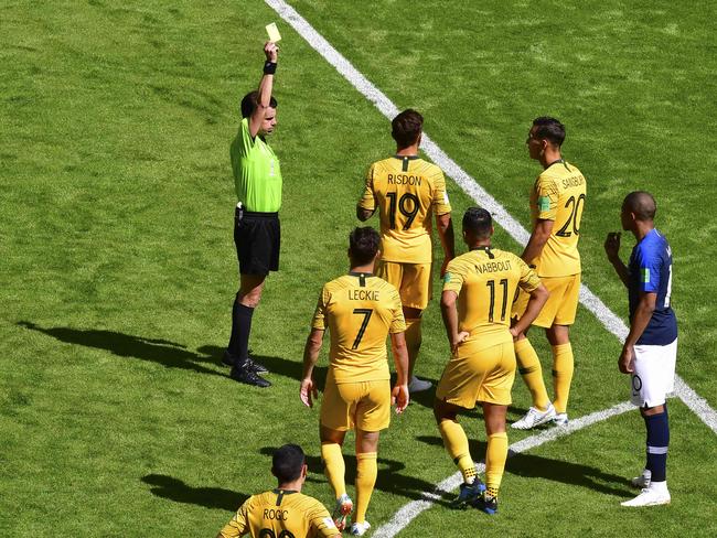 Uruguayan referee Andres Cunha (L) presents Australia's defender Joshua Risdon (C, #19) with a yellow card for the challenge on Griezmann. Pic: AFP