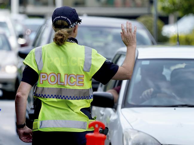 A police officer stops a driver at a checkpoint at Coolangatta on the Queensland - New South Wales border, Thursday, April 9, 2020. The Queensland Government  is introducing new border control measures effective Friday where Queenslander residents crossing the border back into Queensland will also now need a permit.  (AAP Image/Dave Hunt) NO ARCHIVING