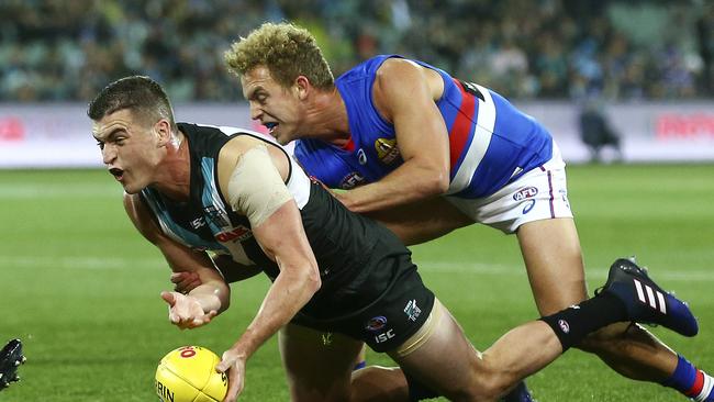 Tom Rockliff fights his way to the ball ahead of Bulldog Mitch Wallis. Picture SARAH REED