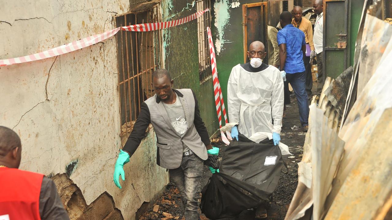 Rescuers carry a body after a fire at a Koranic school killed at least 26 children and two teachers in Monrovia, Liberia.