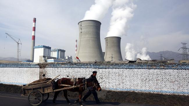 A farmer leads a cart walking past a coal-fired power plant in Datong County. Picture: Getty