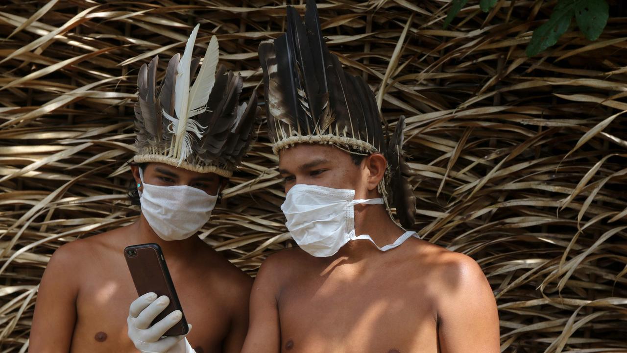 Men from the Satere-Mawé tribe are seen wearing surgical masks after a coronavirus outbreak in a nearby city. Picture: Ricardo Oliveira/AFP