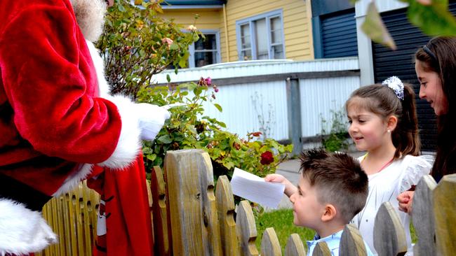 Santa Claus visits Leila, 7, Jasmine, 5, and Ali Mohamad during their home quarantine. Picture: HEIDI ROBNIK.