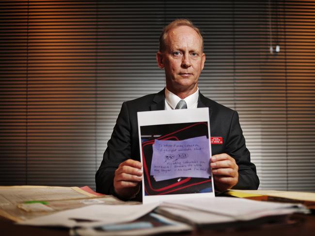 Detective Inspector Glen Browne, the Commander Missing Persons Registry pictured in his office at Parramatta with a note found with the Echo Point Man in 2004. Picture: Sam Ruttyn