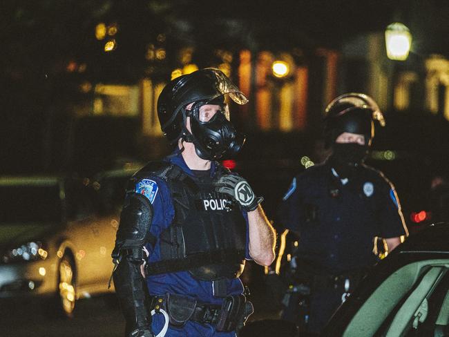 Police in riot gear watch as protesters march in Virginia. Picture: Getty Images/AFP