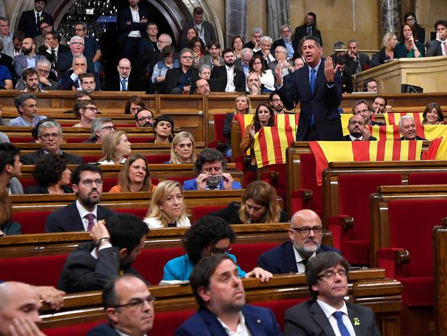 Leader of the Popular Party of Catalonia (PPC) Xavier Garcia Albiol (right) talks while members of the Popular Party hold Spanish and Catalan flags before a vote on a motion declaring independence from Spain on October 27. Picture: Lluis Gene/AFP