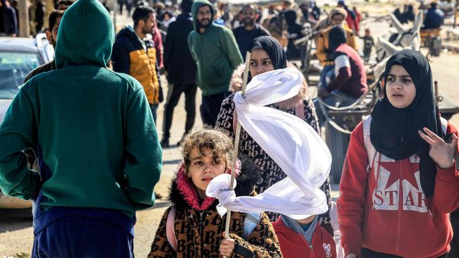 A girl holds a make-shift white flag as she walks with other displaced Palestinians fleeing from Khan Younis. Picture: AFP