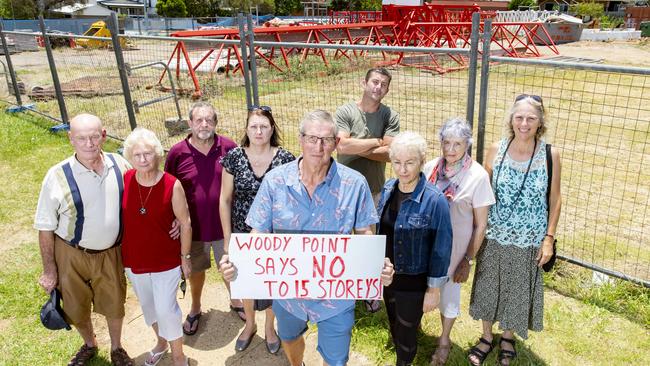 Derek Caccerall poses for a photograph with neighbours of the development site bounded by Kate Street, Lilla Street, and Gayundah Esplanade in Woody Point, Friday, November 29, 2019 (AAP Image/Richard Walker)