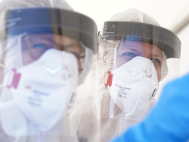 BERLIN, GERMANY - APRIL 23: Employees of the Berlin-Mitte district health office wear PPE protective gear, including masks, visors and suits, demonstrate taking a throat swab from a city employee during a press opportunity at Berlin's first drive-in Covid-19 testing facility the day before its opening during the coronavirus crisis on April 23, 2020 in Berlin, Germany. Germany is seeking to expand its Covid-19 testing capacity in order to test not only health and emergency workers and people with Covid-19 symptoms, but also other parts of the population who might be asymptomatic.  (Photo by Sean Gallup/Getty Images)