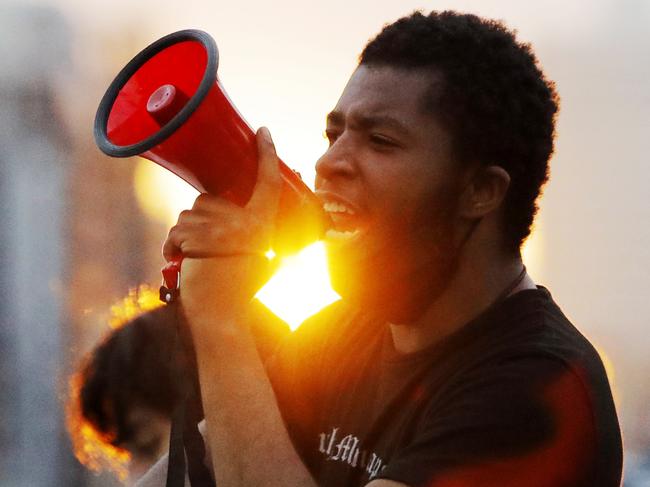 A protest leader chants with demonstrators after curfew in Minneapolis.