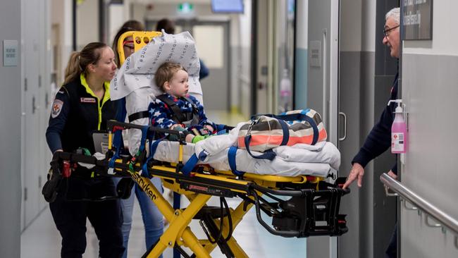 Vance Richards, 2, is attended to by ambulance officers after being brought in with breathing difficulties. Picture: Jake Nowakowski