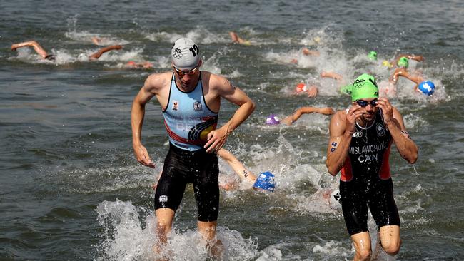 Tyler Mislawchuk (right) emerges from the Seine during the triathlon. (Photo by Ezra Shaw/Getty Images)