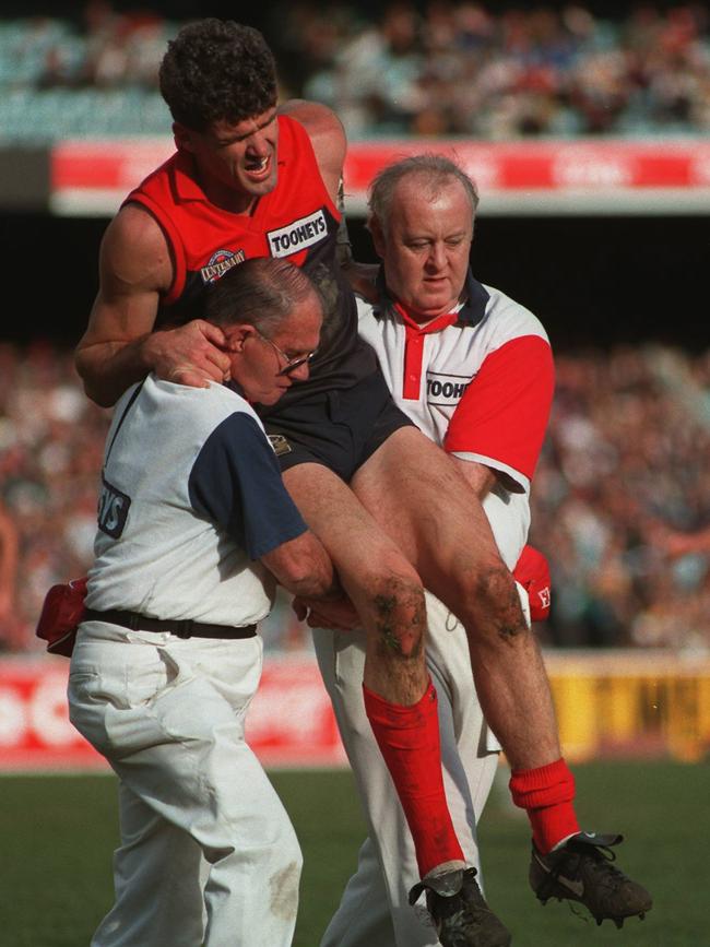 Smith is carried from the ground by trainers with an injured back.