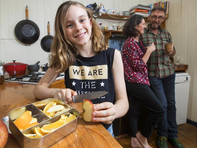 Elsie cuts up fruit for her school lunch which is packed in a non-plastic reusable container. Picture: Lachie Millard