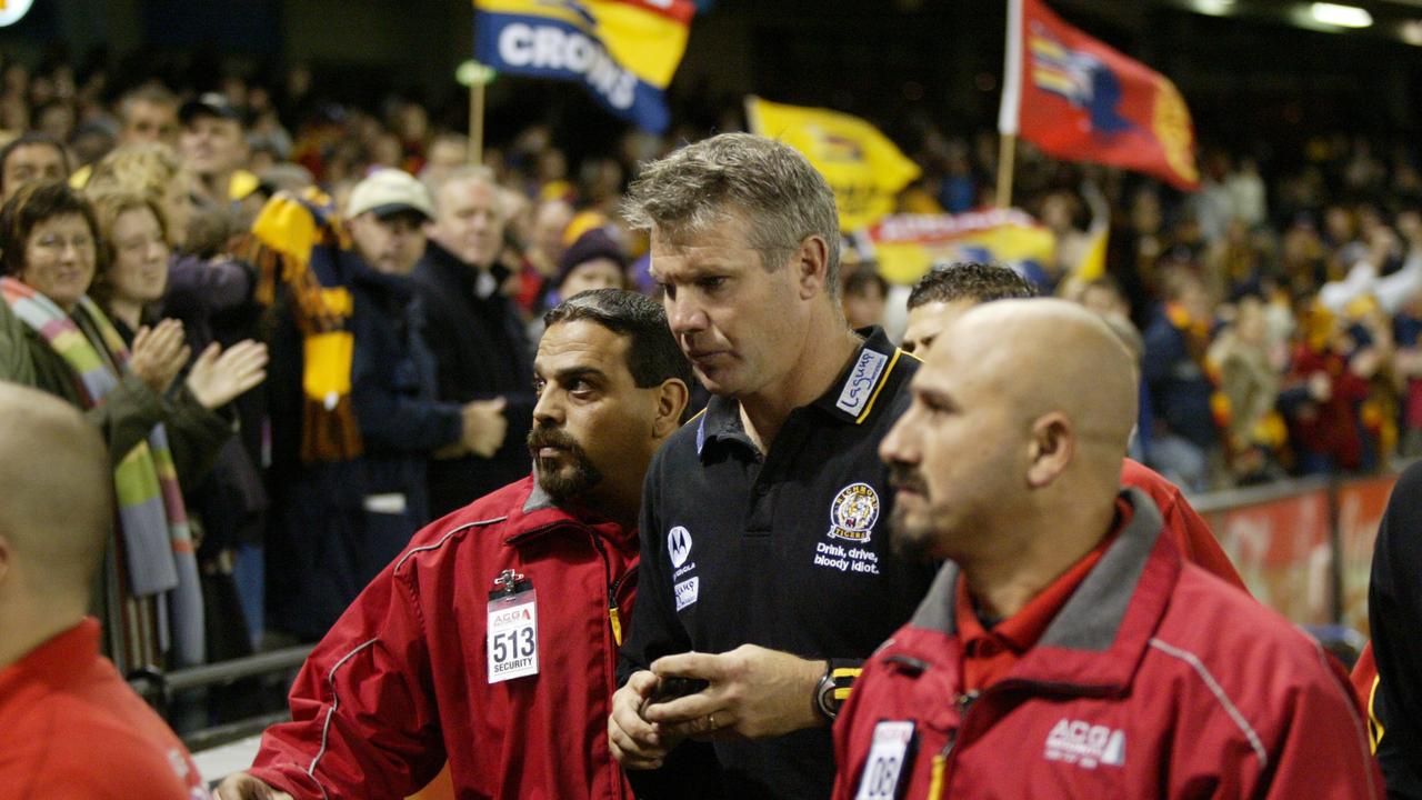 23 Apr 2004 Richmond coach Danny Frawley is flanked by security as he leaves the ground. Re; Crowd, hostile fans. Richmond vs Adelaide Crows at Telstra Dome - sport afl