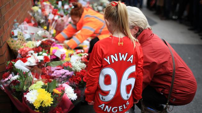 People leave tributes outside Anfield stadium before a memorial service to mark the 27th anniversary of the Hillsborough disaster.