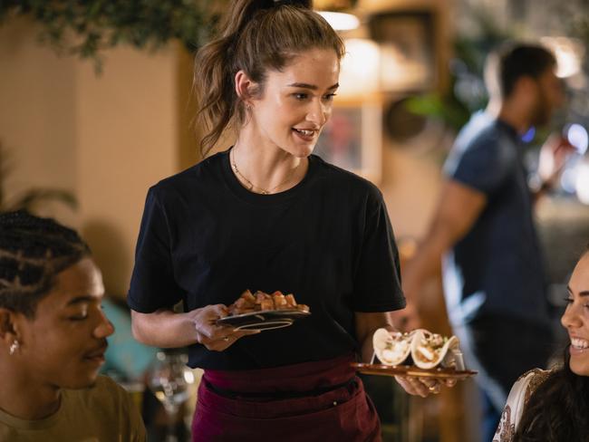 A waitress serving food to customers at a restaurant in Newcastle-Upon-Tyne. istock image