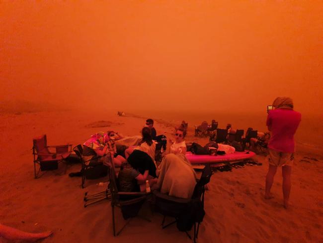 Twitter picture taken by Alastair Prior @alastairprior. People gather together at an evacuation centre on the Beach at Batemans Bay.