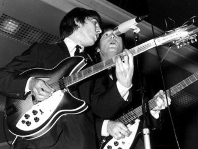 George Harrison and John Lennon on stage at The Beatles’ 1964 Festival Hall concert.